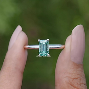 Front view of Green Emerald Cut ring holding in two fingers 