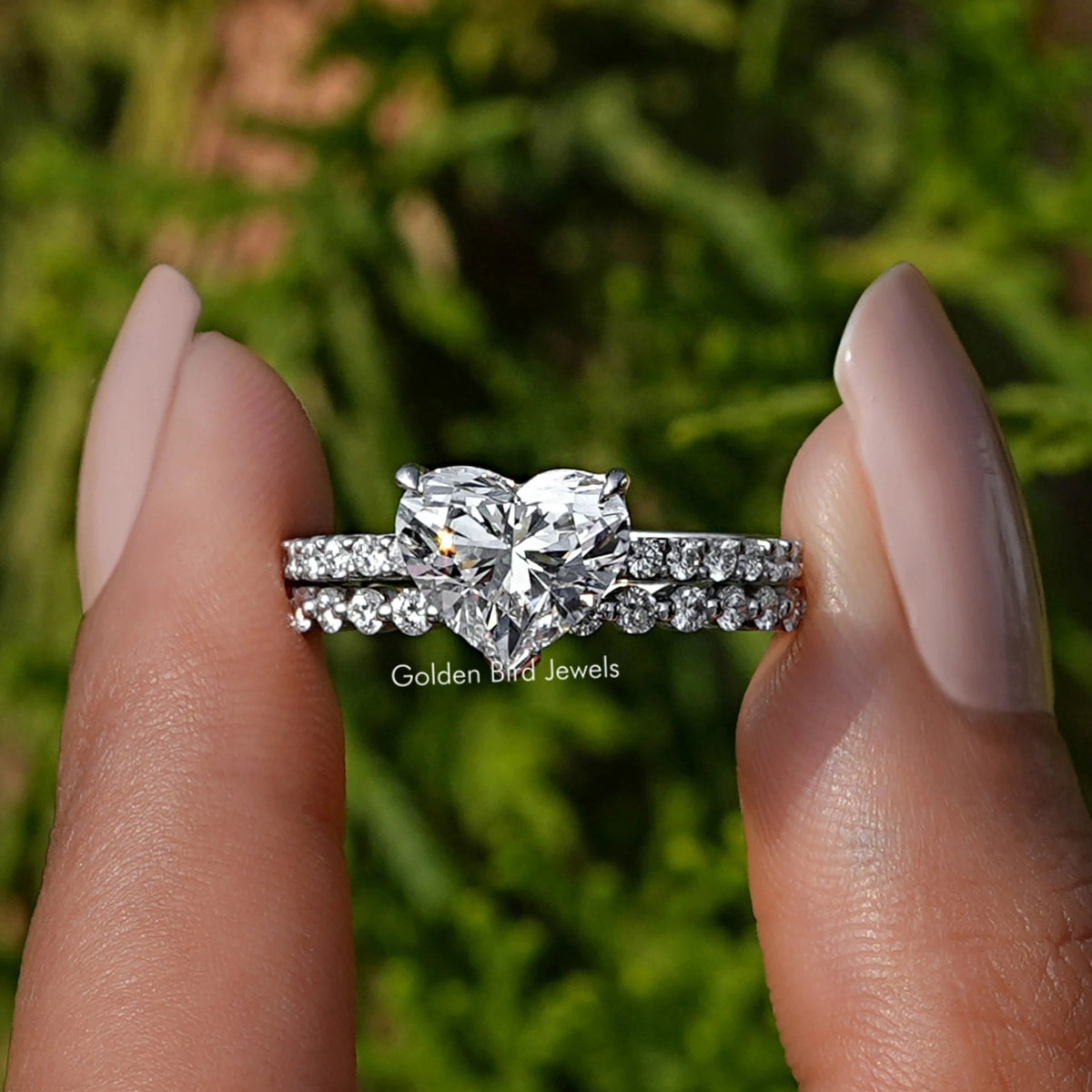 Heart Shaped Lab Diamond Bridal Ring Set held between two fingers