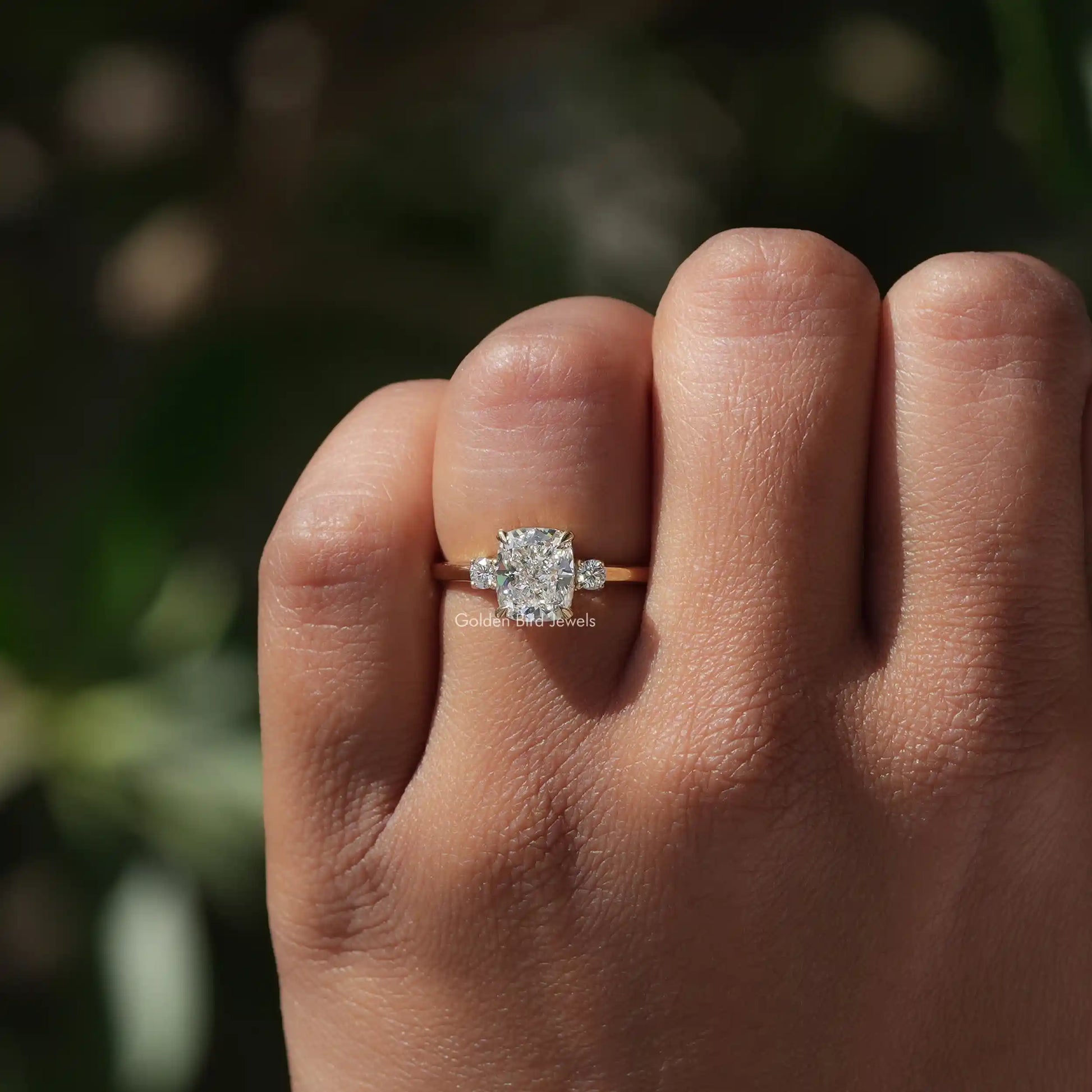 Cushion Shaped Three Stone Engagement Ring In Yellow Gold