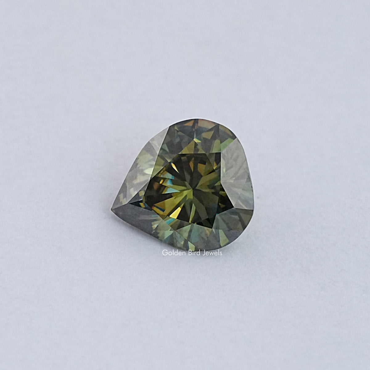 Pear-cut moissanite loose stone with dark green and gold facet reflections
