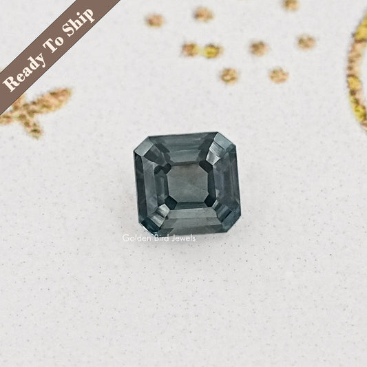 Gray asscher-cut moissanite gemstone with square step facets and dark shine