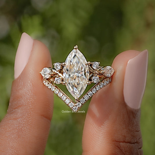Gold-tone marquise cut engagement ring with large center stone and side halos