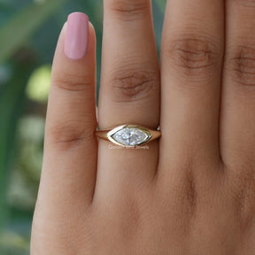 In finger top view of solitaire moissanite  engagement ring in fancy bezel set 