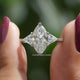 Two fingers holding the Marquise And Triangle Cut Hidden Halo Ring