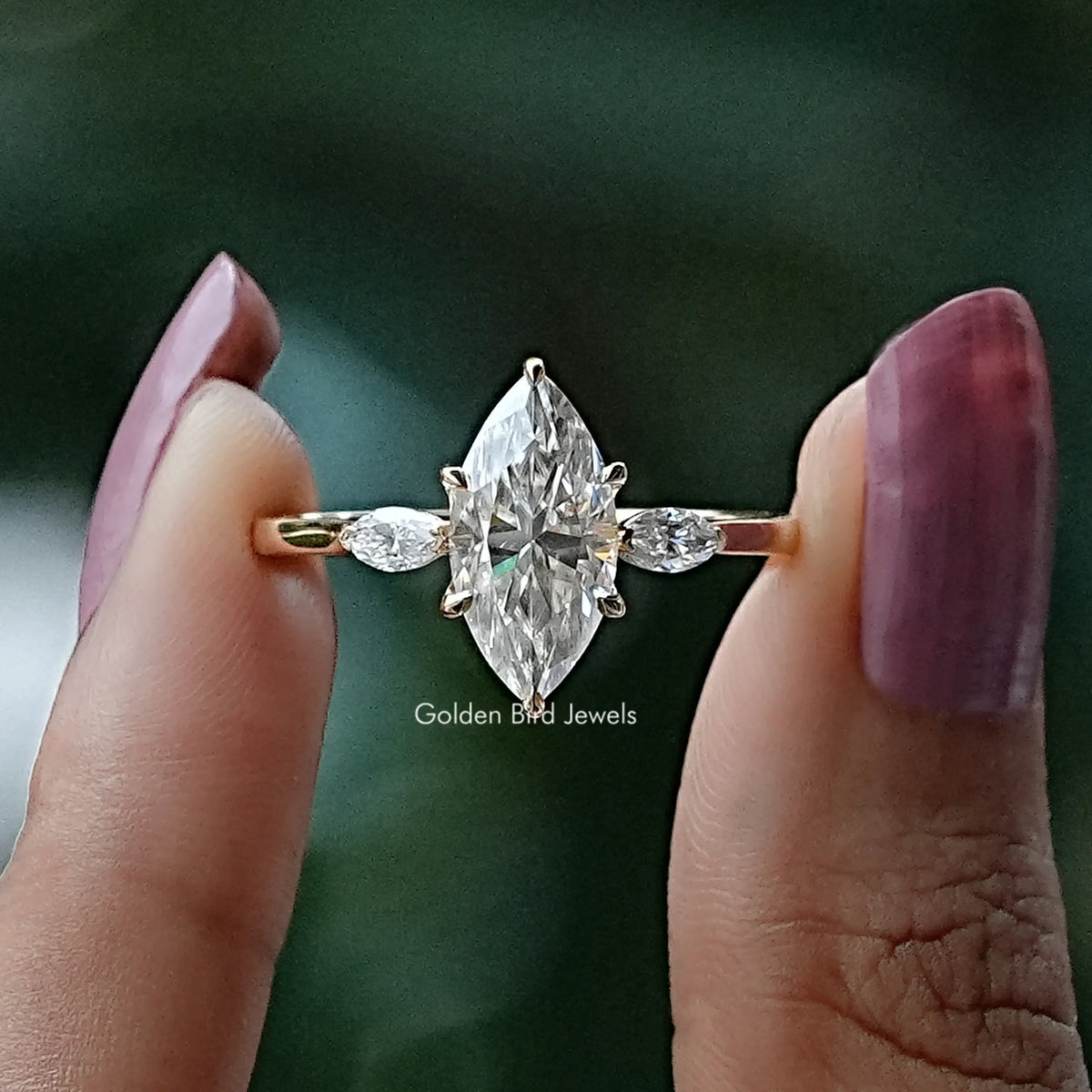 Front View of Marquise Cut Moissanite Three Stone Engagement Ring In two Fingers