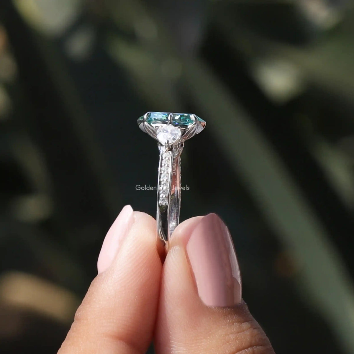 Side View of Marquise Cut Three Stone Accent Stone Ring In two fingers