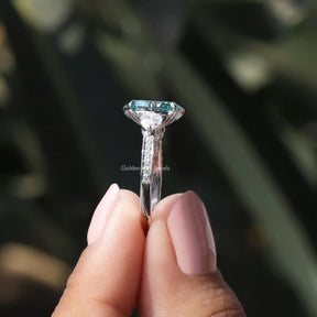Side View of Marquise Cut Three Stone Accent Stone Ring In two fingers