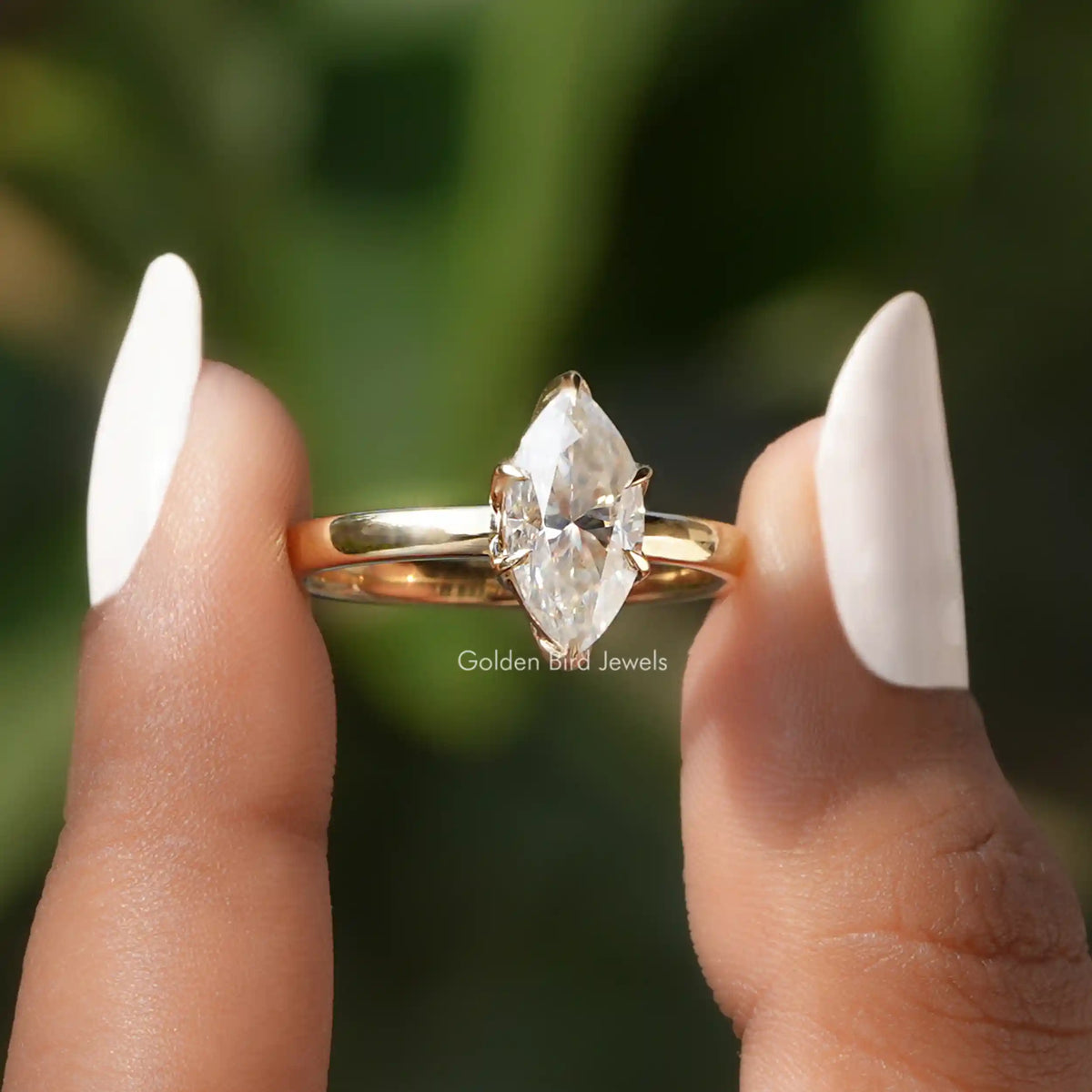 Front View of Marquise Cut Solitaire Engagement Ring In two Fingers