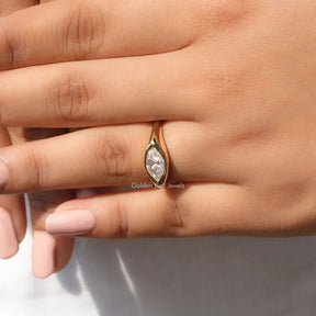 In finger front view of halo moissanite engagement ring in yellow gold 