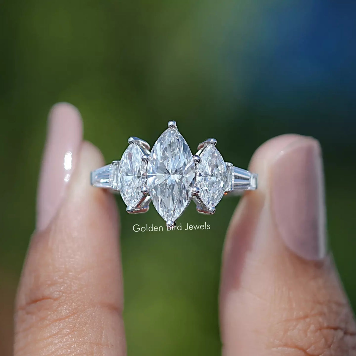 Two fingers holding the Marquise Tapered Baguette Cut Diamond Five Stone Ring