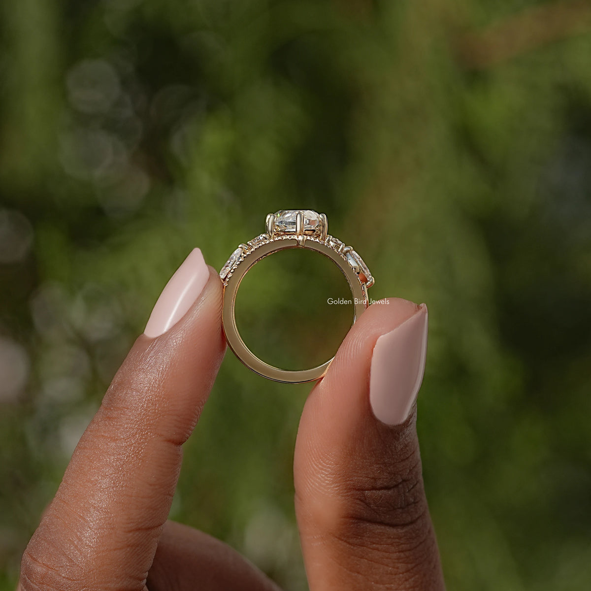 Gold-tone engagement ring viewed from above with marquise setting and halo detail