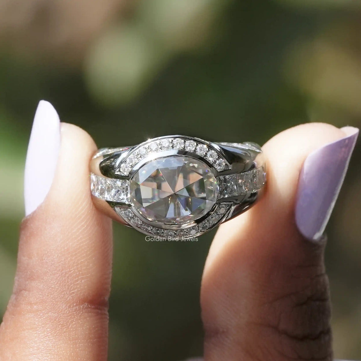 Two fingers holding the Rose Cut Oval Halo Engagement Ring