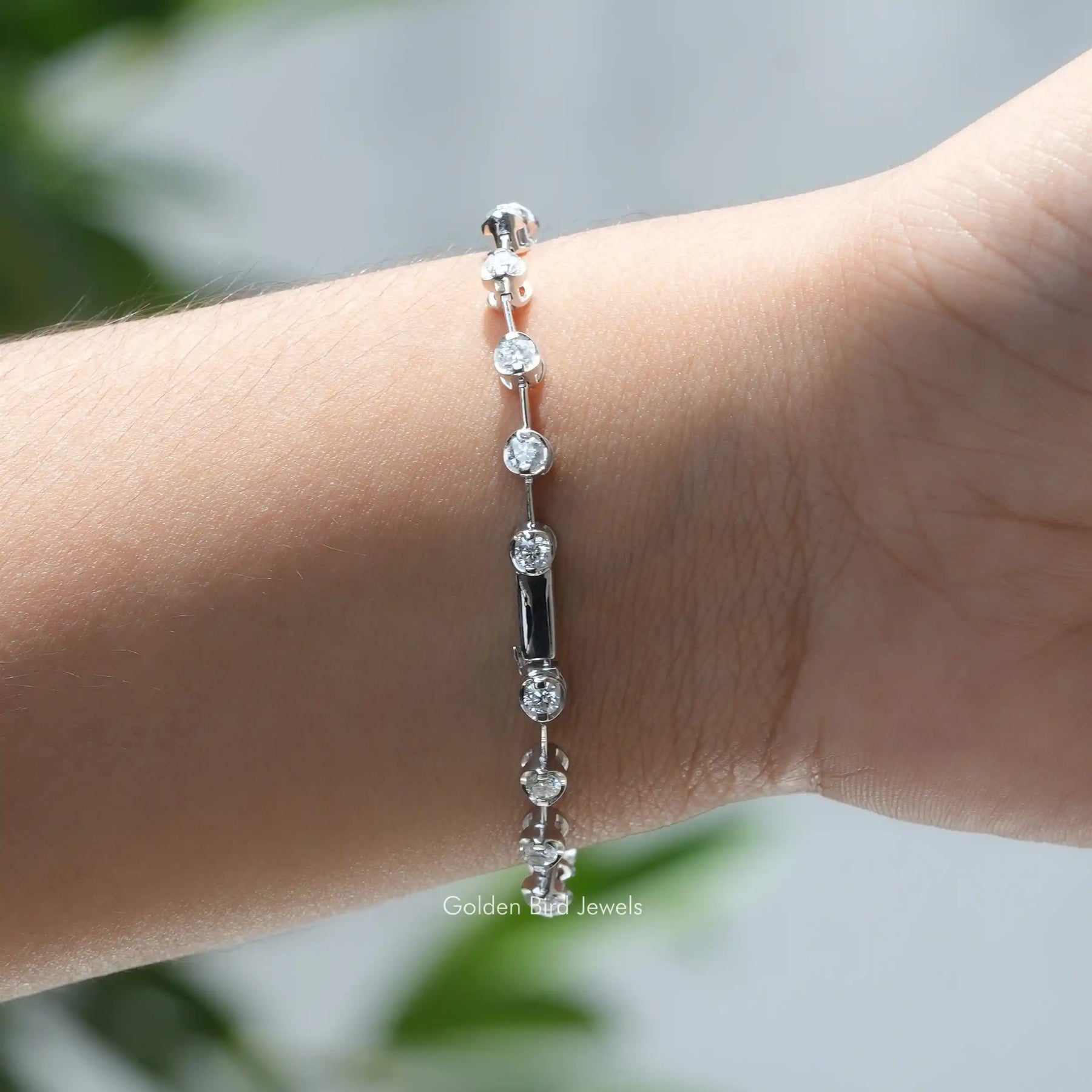 In hand front view of round cut moissanite distance bracelet in secure setting 