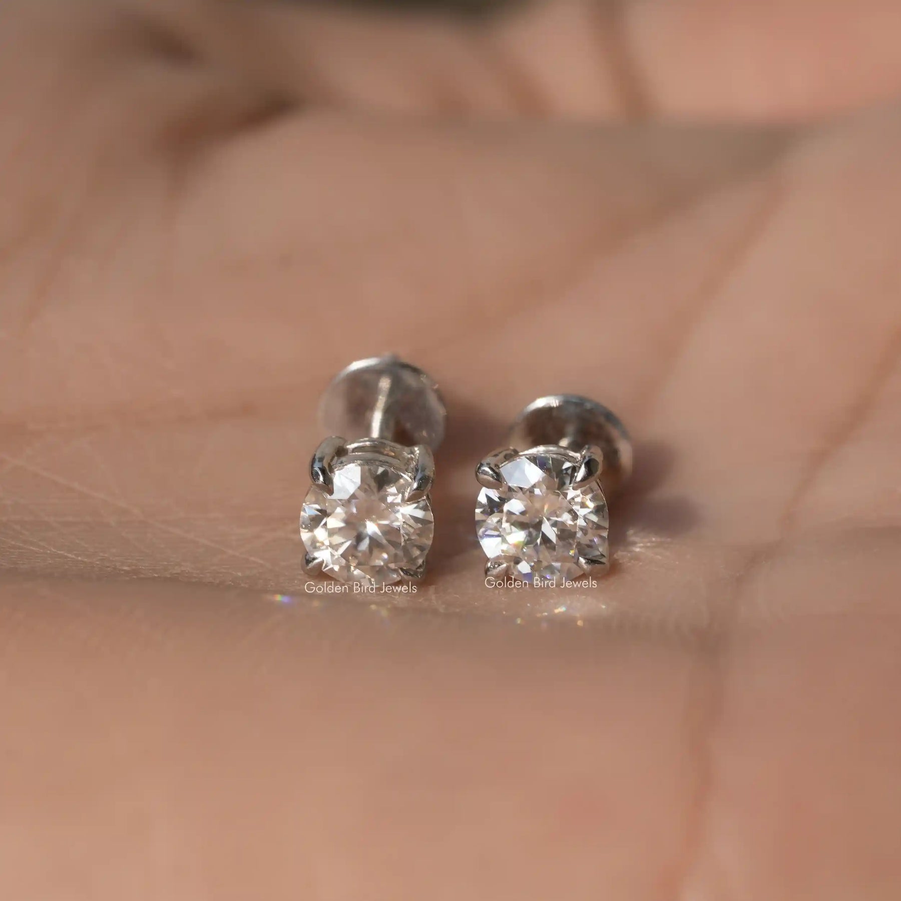 Front view of round cut moissanite earrings in white gold 