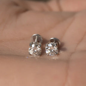 Front view of round cut moissanite earrings in white gold 