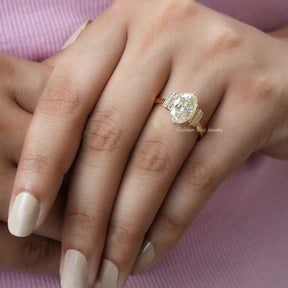 Moval shape halo engagement ring with white side stones