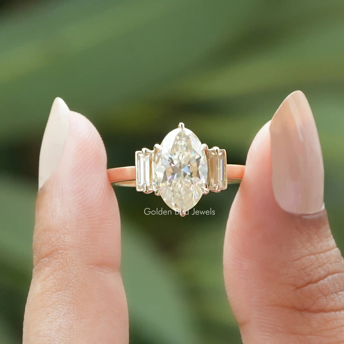 Moissanite moval cut three stone ring on holding two fingers
