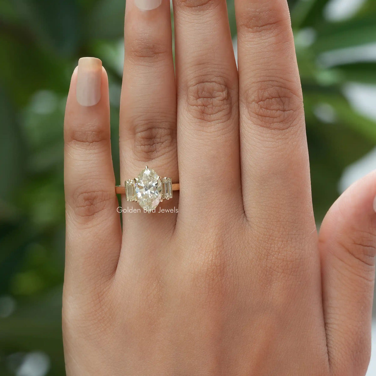 Finger view of moissanite  engagement ring in three-stone