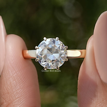 Round moissanite solitaire ring with prong-set center stone and thin gold-toned band
