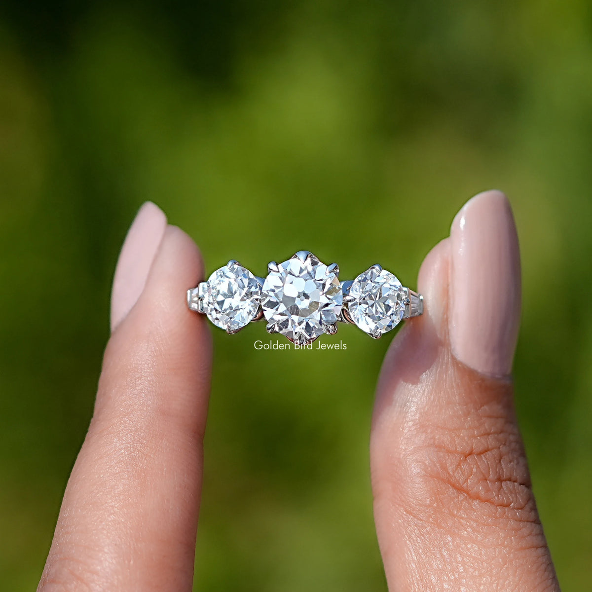 Two fingers holding the Old European Round Cut Lab Diamond Five Stone Ring In White Gold