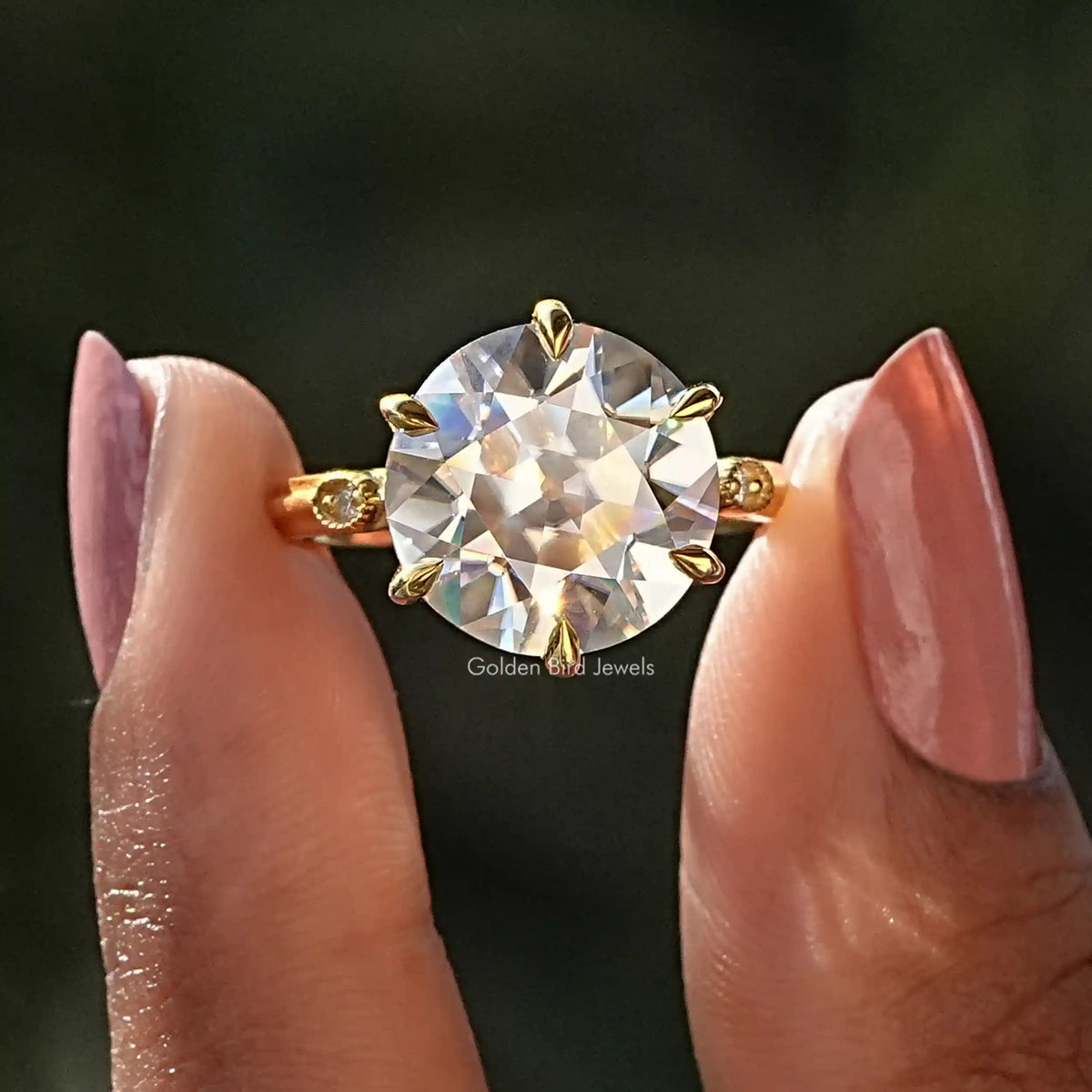 Two fingers holding the Old European Round Cut Moissanite Engagement Ring