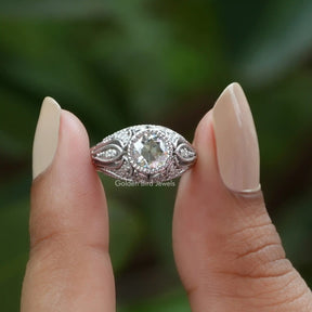 Front View of OEC Round Cut Moissanite Ring In two fingers