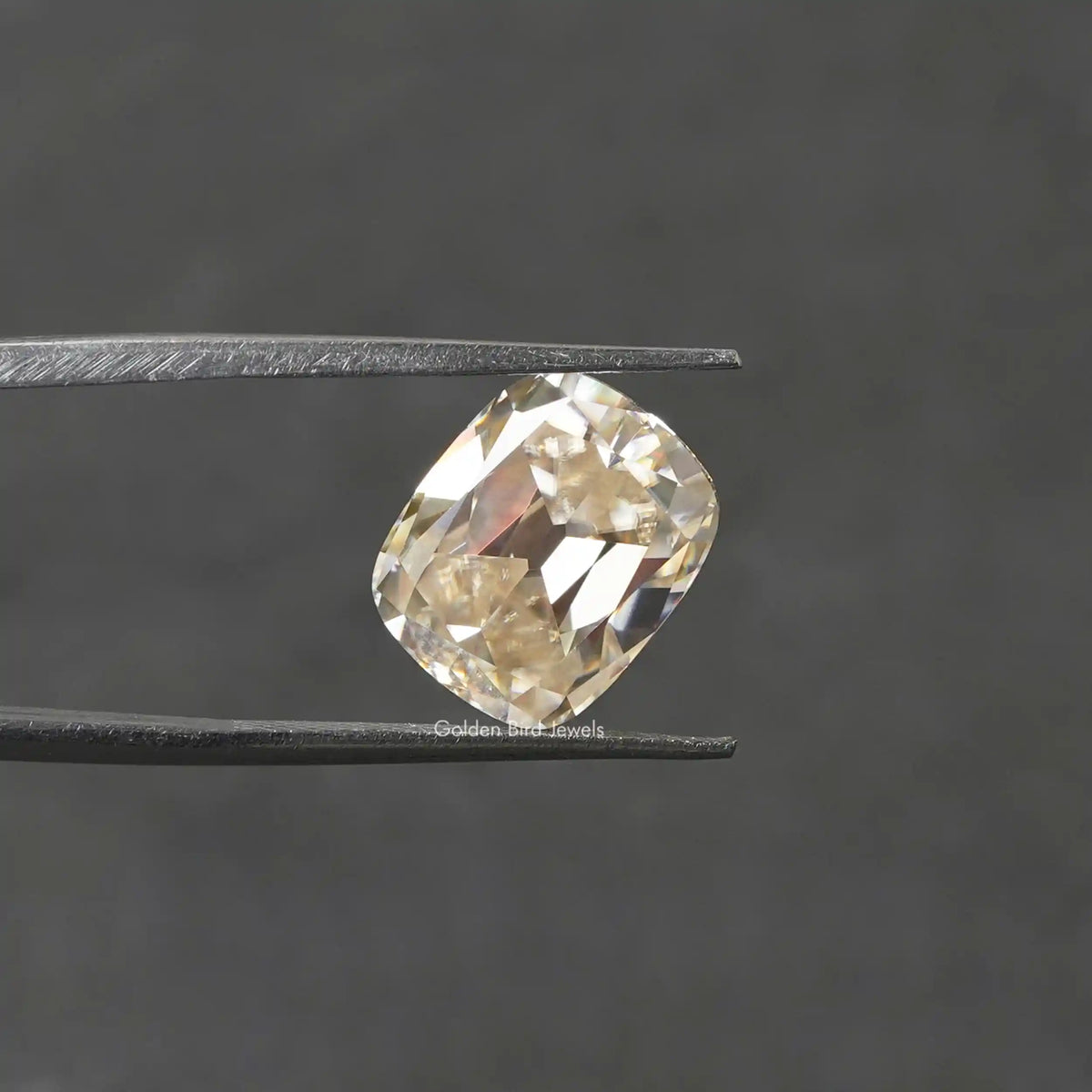 Tweezer view of Old Mine cushion Cut Loose moissanite