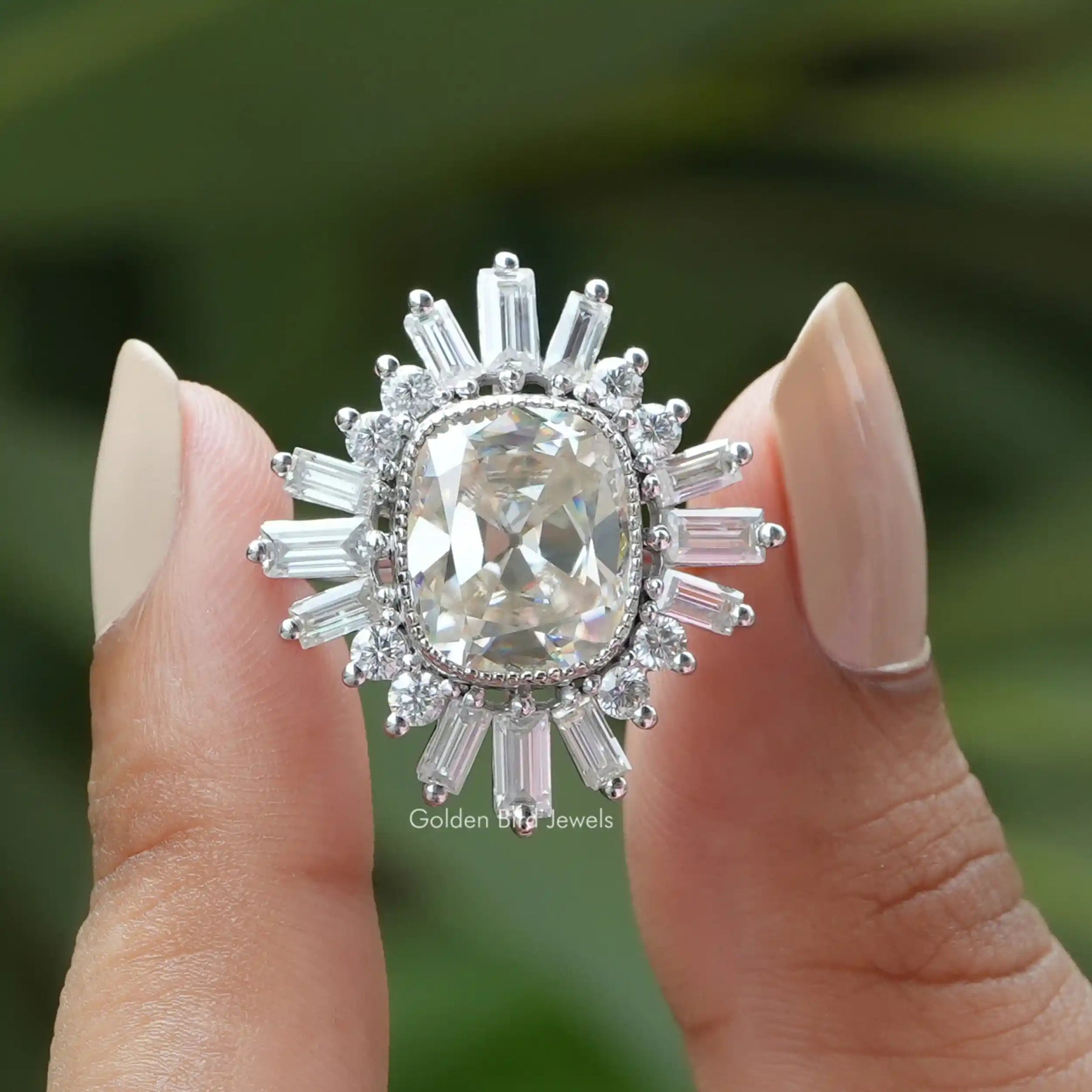 Two fingers holding the Old Mine Cushion Cut Moissanite Halo Engagement Ring 