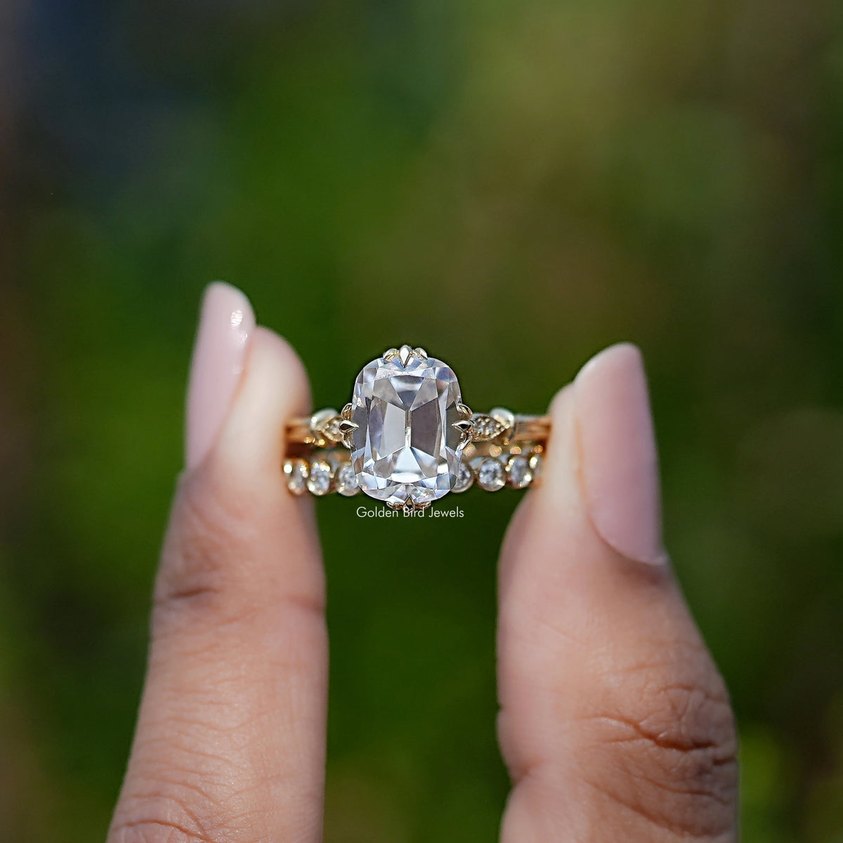 Front view of Old Mine Cushion Cut moissanite engagement ring holding in two fingers 