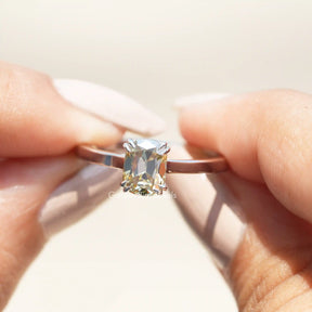 Two fingers holding the Old Mine Cushion Cut Moissanite Solitaire Ring