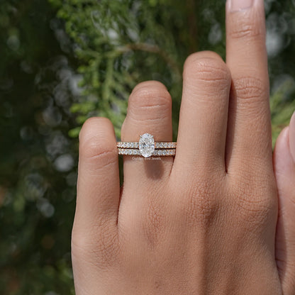 Oval-cut moissanite wedding ring set with pavé bands on a hand