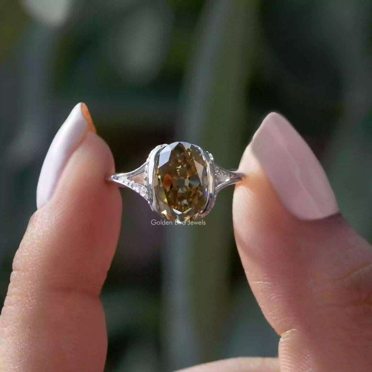 Two fingers holding the Old Mine Oval Cut Half Bezel Set Engagement Ring