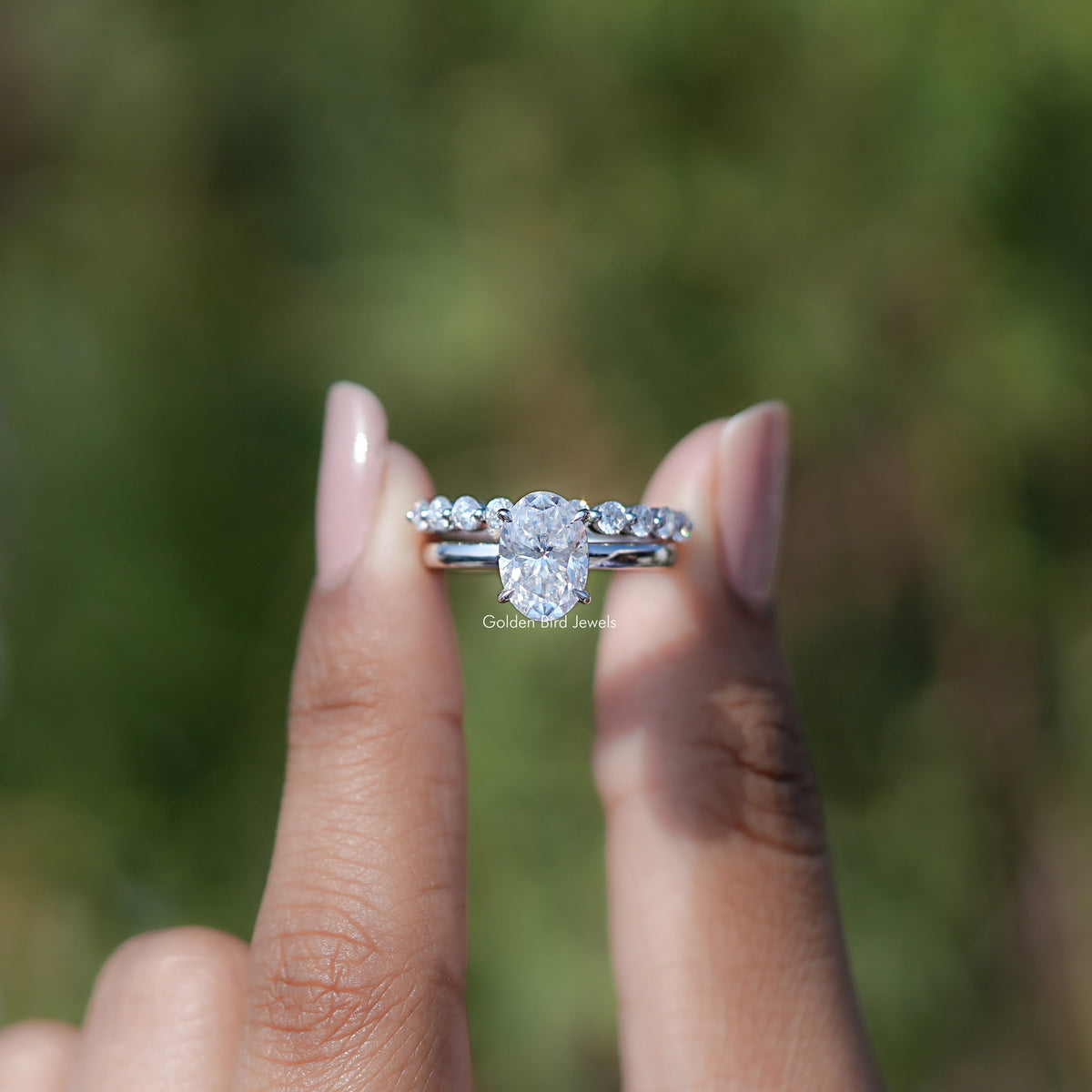 Front view of Oval cut moissanite engagement ring holding in two fingers 