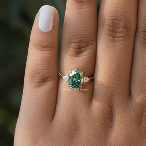 View of Green Oval And Colorless Trangle Cut Three Stone Ring In Yellow Gold