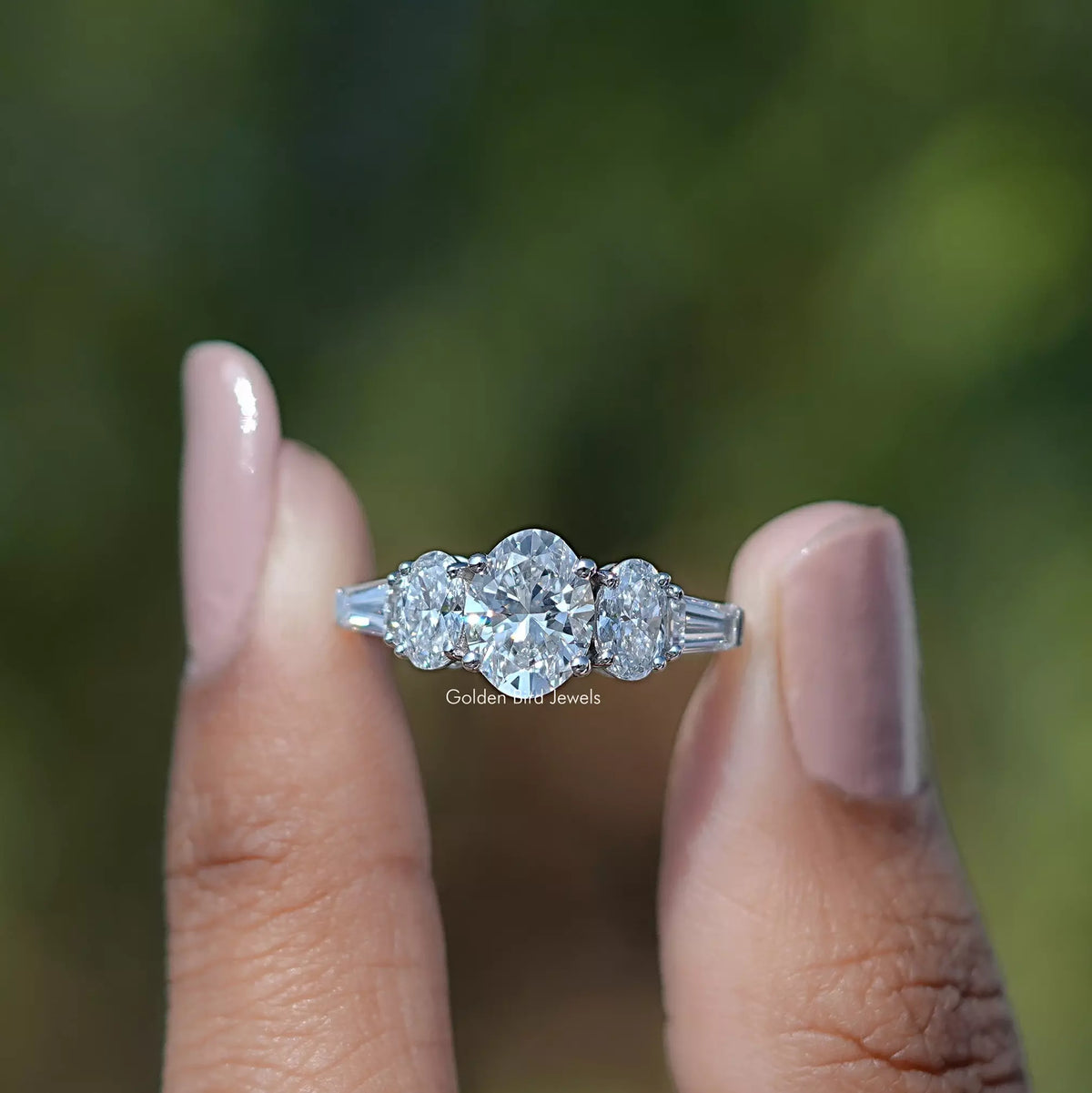 Front View of Oval Cut Lab Grown Diamond Five Stone Engagement Ring In two Fingers