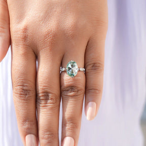 Close-up view of a rose oval cut moissanite ring with delicate accents.