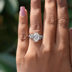 In finger view of oval shaped ring crafted with white side stones 