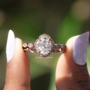 Two fingers holding the Moissanite Oval Halo Wedding Ring