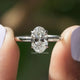 Two fingers holding the Oval Cut Lab Diamond Solitaire Engagement Ring
