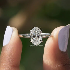 Two fingers holding the Oval Cut Lab Diamond Solitaire Engagement Ring