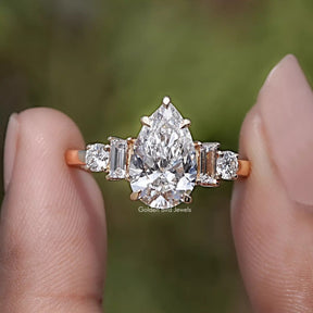 Pear And Baguette Cut Lab Diamond Five Stone Ring Between Two Fingers