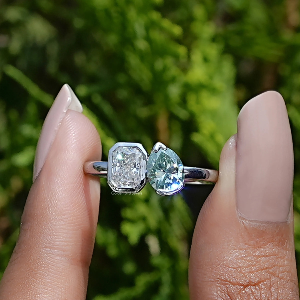 Front View of Pear And Radiant Cut Moissanite Toi Et Moi Ring In two Fingers