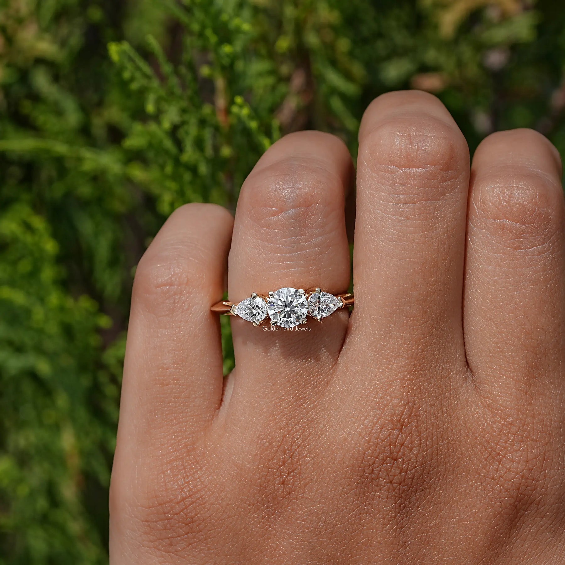 View of Pear And Round Cut Lab Diamond Three Stone Ring In Yellow Gold