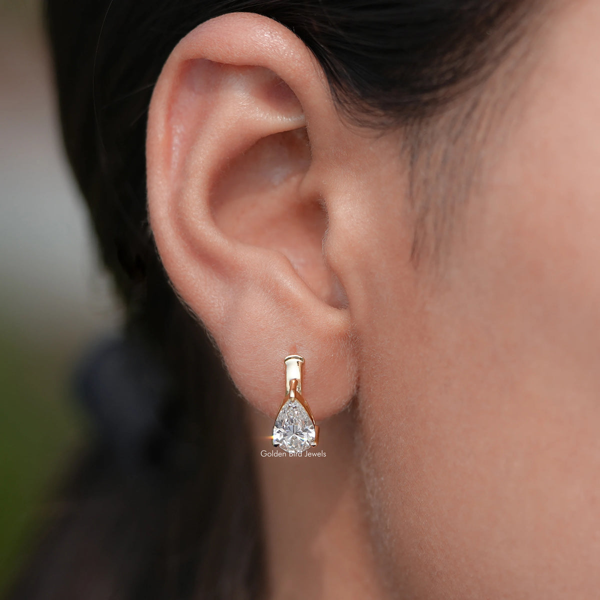 In Ear View of Pear Cut Diamond Solitaire Huggie Hoop Earrings