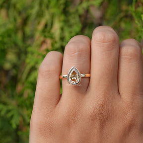 In finger front view of Yellow Moissanite Bezel Set Solitaire Ring  
