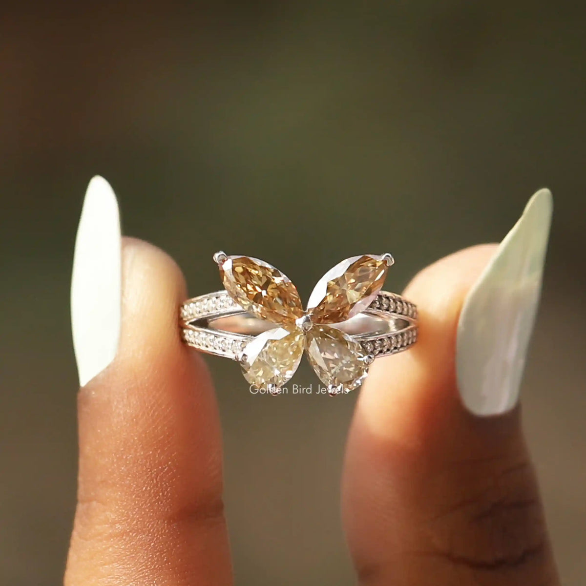 Two fingers holding the Pear Marquise Cut Moissanite Engagement Ring