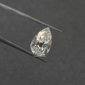 Tweezer view of Off White Old Mine Pear Cut Loose moissanite 