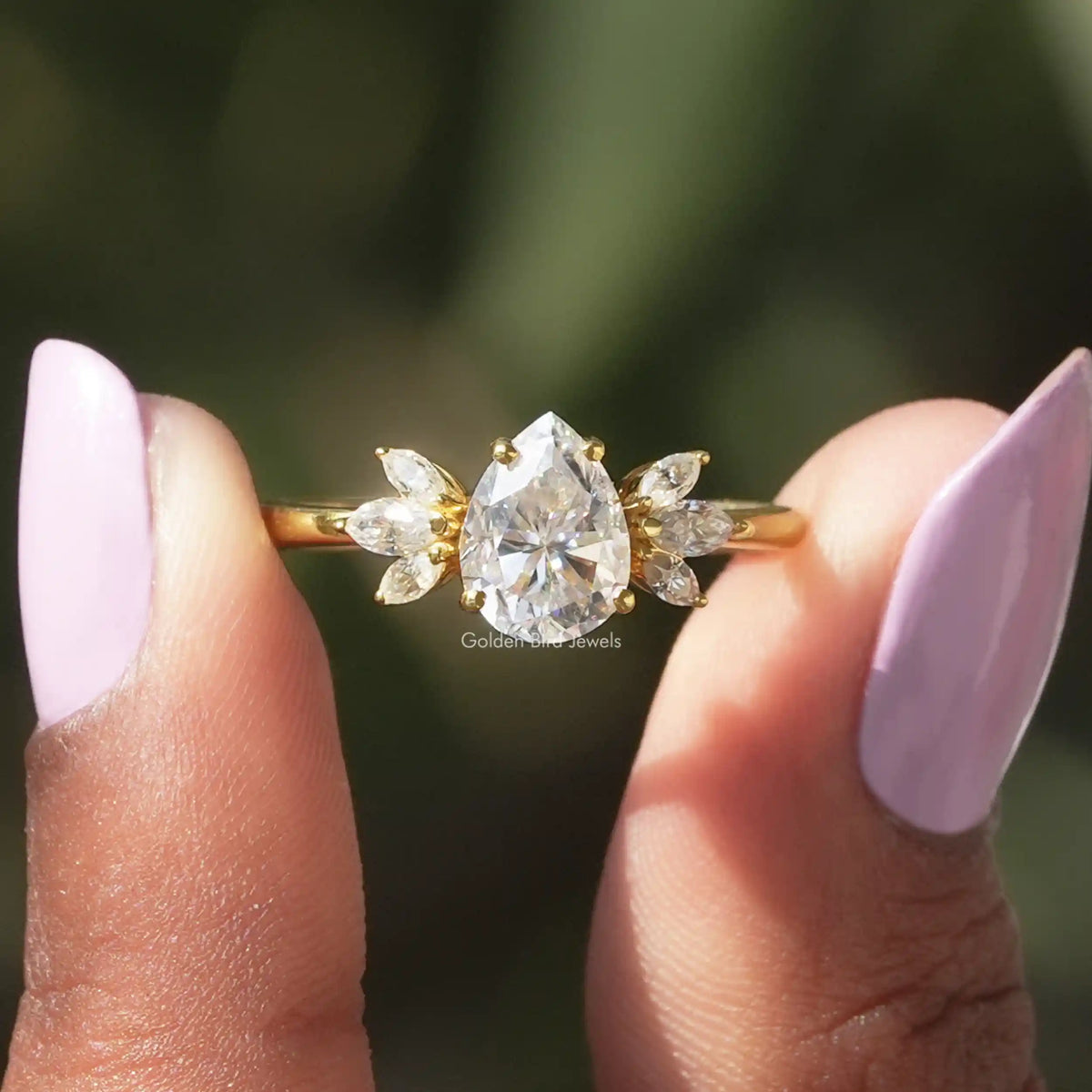 Two fingers holding the Pear Cut Marquise Engagement Ring