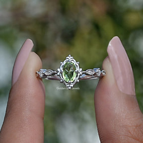 Two fingers holding the Peridot Green Oval Cut Gemstone Accent Ring
