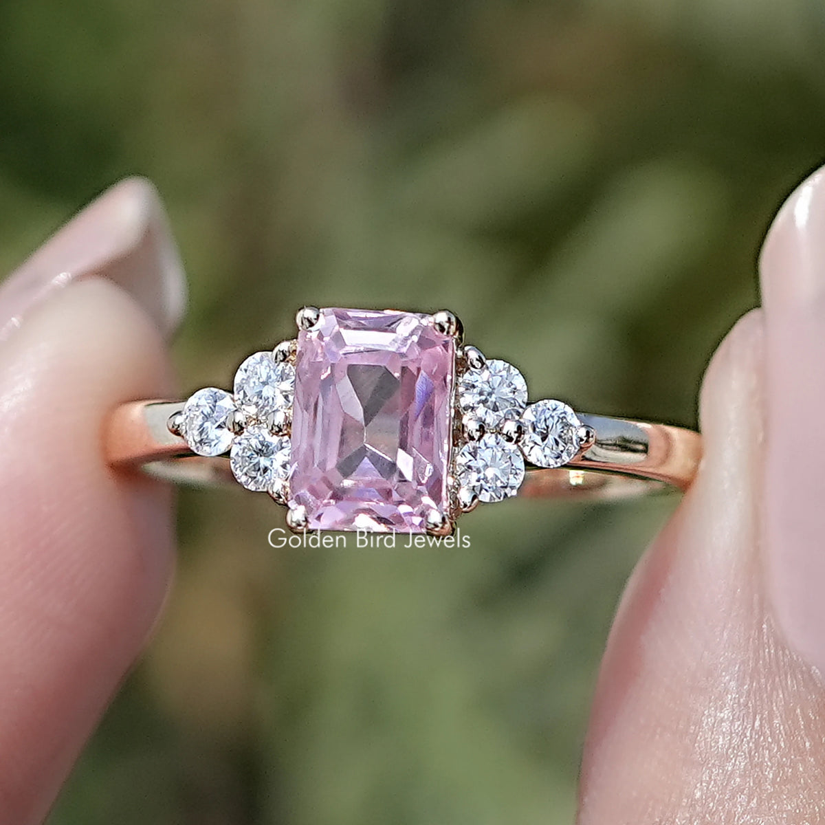 Front view of Pink Emerald Gemstone Accent Engagement Ring in two fingers 